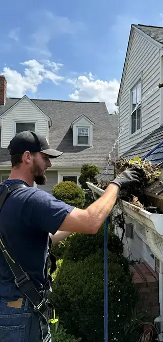 A Cipco Fence employee cleaning gutters